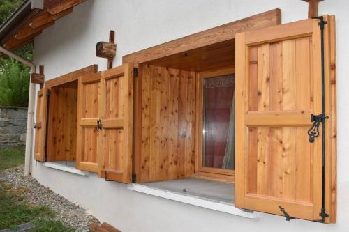 une rangée de portes en bois sur le côté du bâtiment dans l'établissement Charmant logement de 25m2 dans maison de Pays, à Les Vigneaux