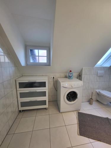 uma casa de banho com uma máquina de lavar roupa e um lavatório em Beautiful Cozy apartments close to lakes and nature parks em Schwandorf