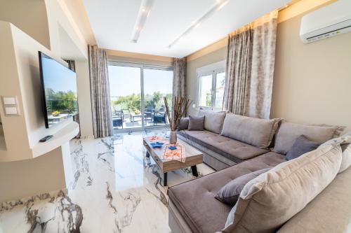 a living room with a couch and a tv at Thomas Villa Hersonissos - Private Pool - Sleeps 7 in Hersonissos