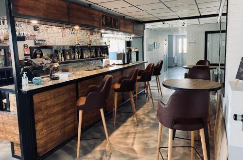 a bar with chairs and tables in a restaurant at Domaine de la Mer in Woignarue