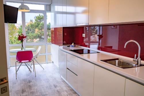a kitchen with red and white cabinets and a table at Central Bliss in Suceava