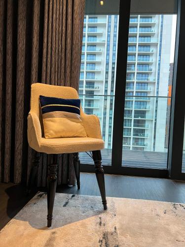 a chair with a pillow in a room with a window at Staycity One Bedroom Luxury Apartment in London