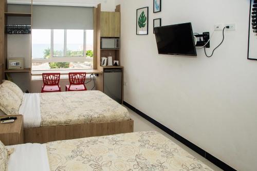 カルタヘナ・デ・インディアスにあるApartamento Ganem 505aのベッド2台、薄型テレビが備わるホテルルームです。