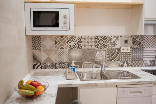 una cocina con fregadero y un bol de fruta en Apartamentos Turísticos A Tu Verita, en Jaraíz de la Vera