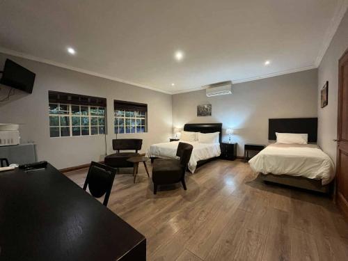 a hotel room with two beds and a table and chairs at ilanda Guest House in White River
