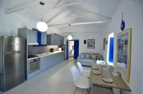 a kitchen and living room with a table and chairs at Douskos by the Sea in Mandraki