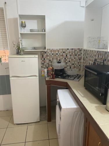 uma cozinha com um frigorífico branco e um micro-ondas em Relax Time Dumanoir em Capesterre-Belle-Eau