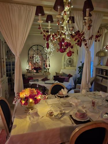 uma sala de jantar com uma mesa com uma toalha de mesa branca em Chambres d'hôtes Jardin D'ivoire em Saint-Gervais-la-Forêt