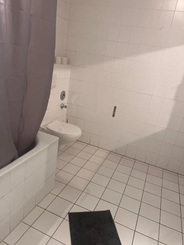 uma casa de banho branca com um WC e uma banheira em casabella em Leverkusen