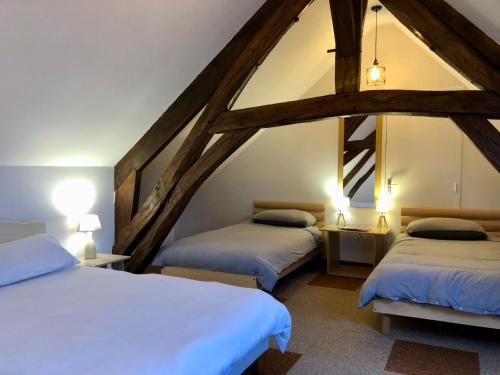 Cette chambre mansardée comprend 2 lits et 2 lampes. dans l'établissement Maison Lavande le grande gite, à Menetou-sur-Nahon
