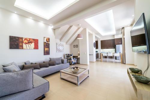 a living room with a couch and a table at Thomas House Hersonissos - Private Pool - Sleeps 6 in Hersonissos