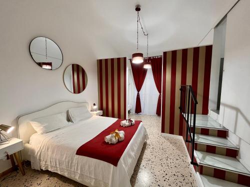 Palazzo delle Logge في باليرمو: غرفة نوم بسرير ابيض بخطوط حمراء وبيضاء
