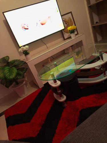 a living room with a glass table and a red rug at Triad apartments in Nairobi