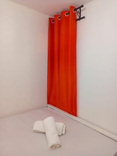 a bathroom with a red curtain and two towels at Triad apartments in Nairobi