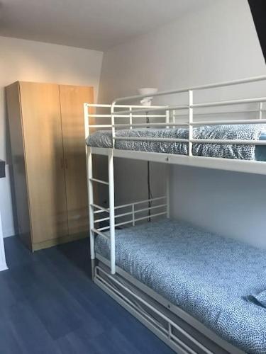 a room with two bunk beds and a cabinet at Maison ville 50m2 5 personnes in Saint-Pierre-des-Corps
