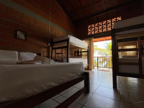 a bedroom with two beds in a room with a window at Hotel Katamaran in Capurganá