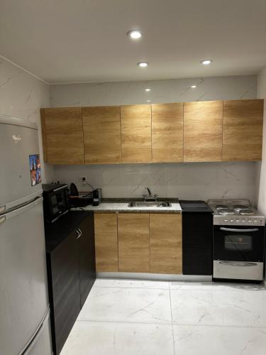 a kitchen with black appliances and wooden cabinets at Purobaires Hotel Boutique in Buenos Aires
