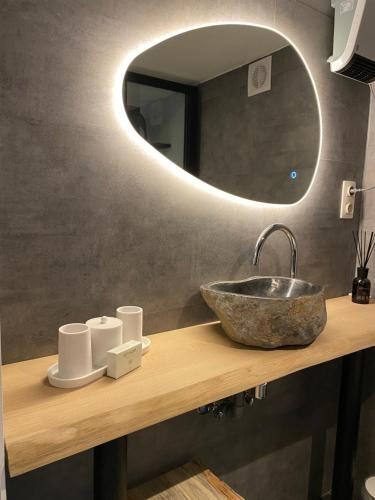 La salle de bains est pourvue d'un lavabo et d'un miroir. dans l'établissement Le logis des Chênes, superbe bungalow dans quartier résidentiel proche de Namur, à Wépion