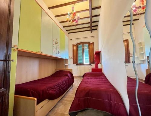 um quarto com duas camas vermelhas num quarto em Appartamento La sosta em San Romano
