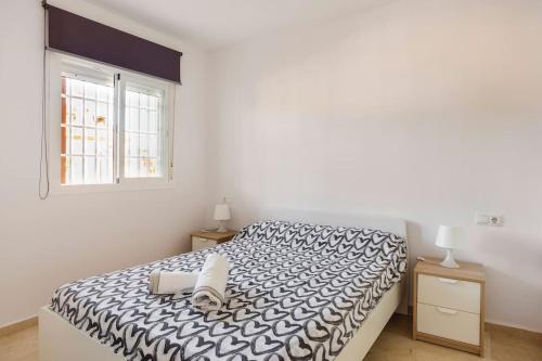 um quarto com uma cama em preto e branco e uma janela em Marina Casares em Casares