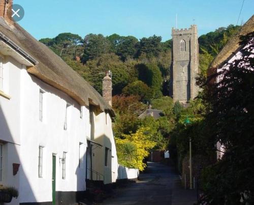 a street with white houses and a clock tower at Minehead Forget me not Cottage in Minehead