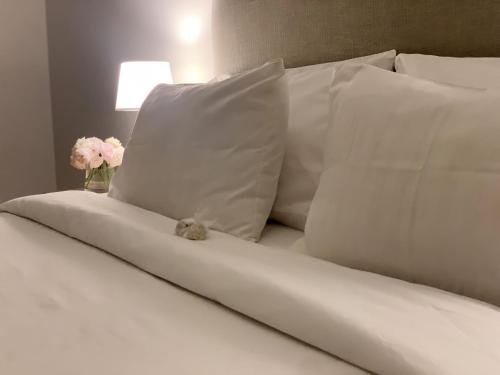 un osito de peluche sentado en una cama con almohadas en Soar Luxury Studio en el centro de Salta en Salta