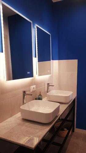 a bathroom with two sinks and a blue wall at Casa Villaggio Pirandello in Agrigento