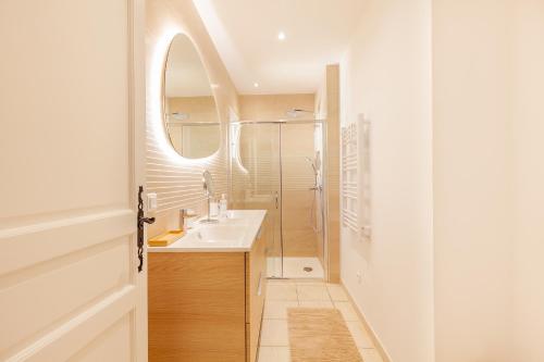 une salle de bain avec un lavabo, une douche et un miroir dans l'établissement Charmante villa avec piscine au calme, à La Garde