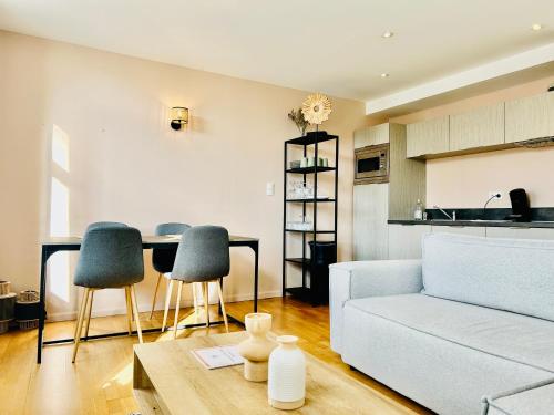 a living room with a couch and a table and chairs at Superbe appartement - Coeur du Vieux-Lille in Lille