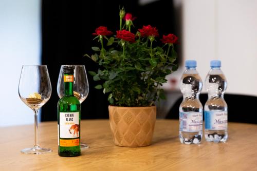 a table with two bottles of wine and a glass at Apartament Aleja Wolności in Nowy Sącz