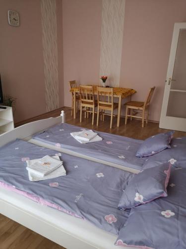 a bed in a room with a table and chairs at Natasa Apartman in Orosháza