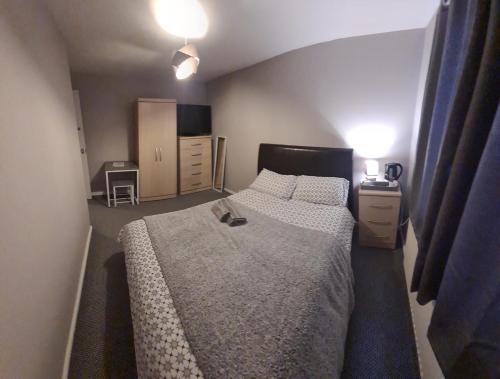 1 dormitorio con 1 cama grande y 2 mesitas de noche en Pinewood house, 