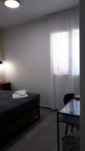 a bedroom with a bed and a table and a window at Casa Villaggio Pirandello in Agrigento