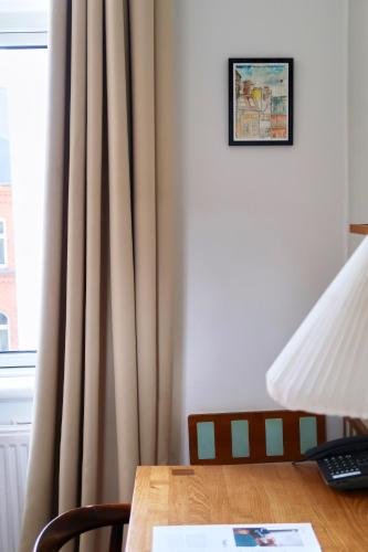 a room with a table and a window with curtains at Hotel Alexandra in Copenhagen