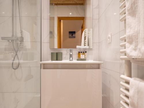 une salle de bain blanche avec un lavabo et un miroir dans l'établissement Appartement Confortable avec Terrasse pour Famille à Huez - FR-1-645-17, à Huez