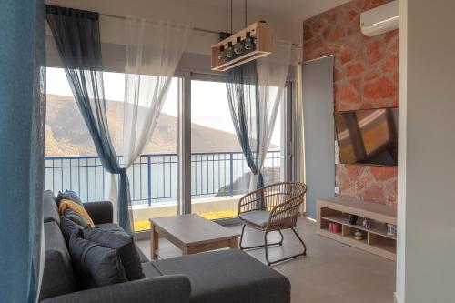 uma sala de estar com um sofá e uma grande janela em Skorponeria Bay Luxury Villas em Skroponeria