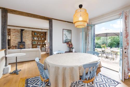 une salle à manger avec une table, des chaises et un canapé dans l'établissement La Misaine, à Pierrefitte-en-Auge