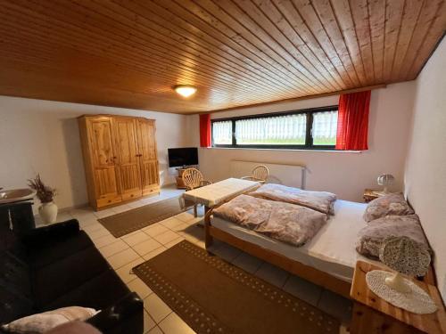 a bedroom with a large bed with a wooden ceiling at Pension Ernst im Herzen des Pfälzerwaldes mit Küche in Elmstein