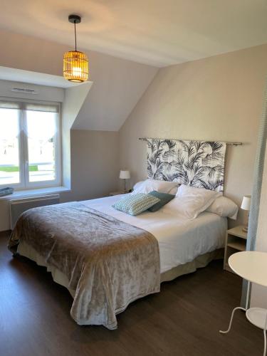 une chambre avec un grand lit et une fenêtre dans l'établissement Le Relais de la Hardiesse 6km Mont St Michel - Chambres d'hôtes doubles, à Courtils