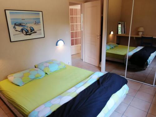 um quarto com 2 camas e um espelho em Landes OCEANES - Chambres privées dans villa avec jardin em Lit-et-Mixe