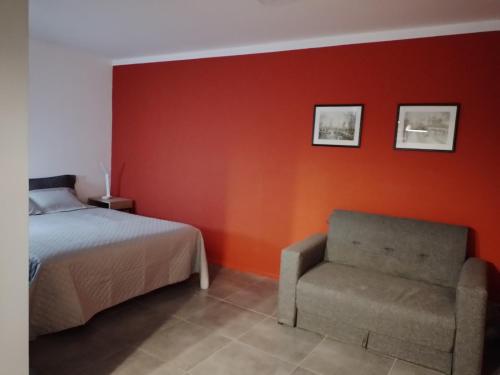 1 dormitorio con 1 cama y 1 silla en Bermellon en Mendoza