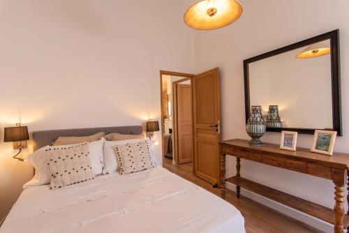 a bedroom with a bed with a mirror and a table at L appartement de Manon, centre historique du vieil Antibes in Antibes