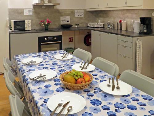 una mesa con platos y un bol de fruta en ella en Bakkegata - Blue House Dormitory en Odda