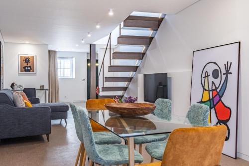 een woonkamer met een glazen tafel en stoelen bij Casa do Batente - By WeHost in Funchal