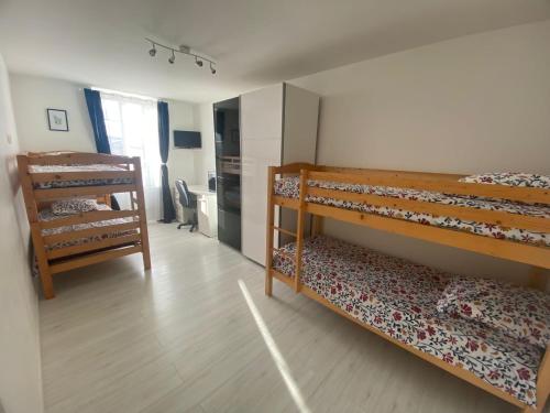 a bedroom with two bunk beds and a kitchen at Gîte 8 personnes in Sainte-Croix-du-Mont