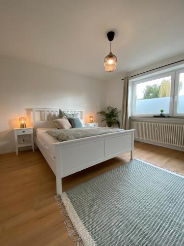 a white bedroom with a bed and a window at Gemütliche Wohnung am Federsee in Bad Buchau