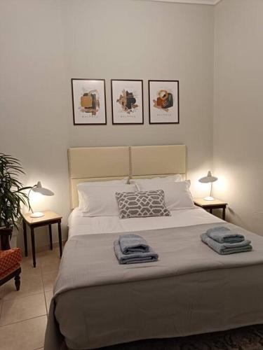 a bedroom with a bed with three pictures on the wall at Κεντρικό ευρύχωρο στούντιο με parking in Larisa