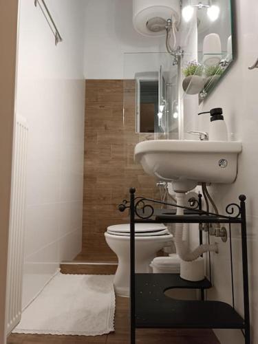 La salle de bains est pourvue d'un lavabo et de toilettes. dans l'établissement Κεντρικό ευρύχωρο στούντιο με parking, à Larissa