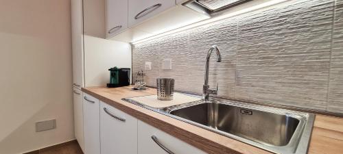 une cuisine avec un évier en acier inoxydable à côté d'une fenêtre dans l'établissement Nel cuore di Santa Maria degli Angeli, à Santa Maria degli Angeli