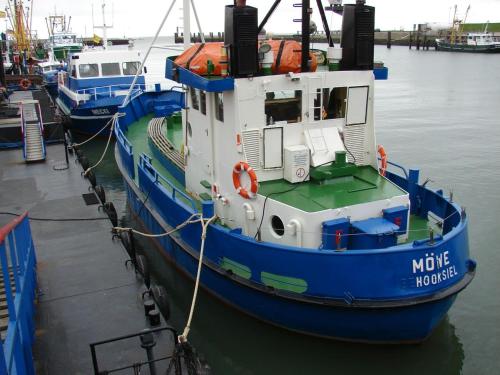 a blue and white boat is docked in the water at Christa & Wilfried Lammermann in Hooksiel